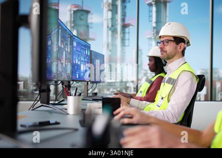 Schwarzer Geschäftsmann und Afrikanerin, die SCADA in der Ölindustrie benutzen Stockfoto