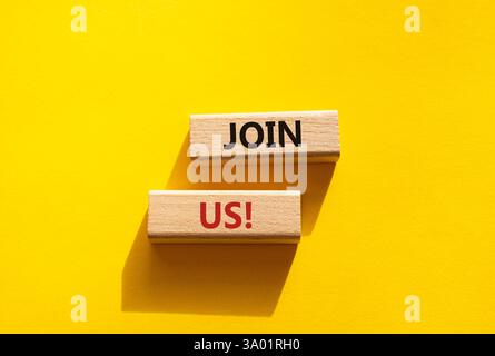 Schließen Sie sich uns an. Concept Word Kommen Sie uns auf Holzblöcken. Schöner gelber Hintergrund. Business und Join US-Konzept. Kopierbereich Stockfoto