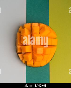 Frisch geschnittene Mangoblätter, die ordentlich auf einem farbenfrohen Hintergrund in einem modernen Ambiente angeordnet sind Stockfoto