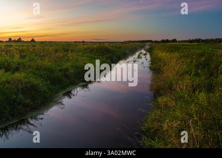 Blick auf einen kleinen, ruhigen Fluss in Ostpolen bei Sonnenuntergang Stockfoto