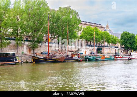Paris, Frankreich - 21. Juli 2010 : South seine Deich entlang des Quai de Conti (Straße). Alte Schiffe liegen am Ufer. Stockfoto