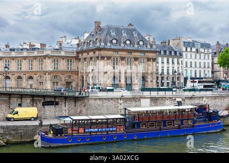 Paris, Frankreich - 21. Juli 2010 : South seine Deich. Der westliche Flügel des Instituts de France über einem schwimmenden französischen Restaurant. Stockfoto