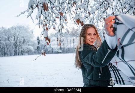 Schöne junge Frau ist draußen im Winterwald. Stockfoto