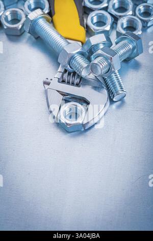Verstellbare Schlüsseldetails und Schraubenmuttern auf metallischem Hintergrund Stockfoto