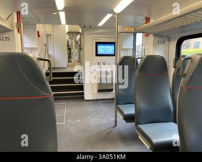 Innenraum eines Caltrain-Zugwagens mit mehreren Sitzplätzen, eine Treppe, die zu einer anderen Ebene führt, und ein digitales Informationsdisplay in der Nähe des Eingangs - Menlo Park Stockfoto