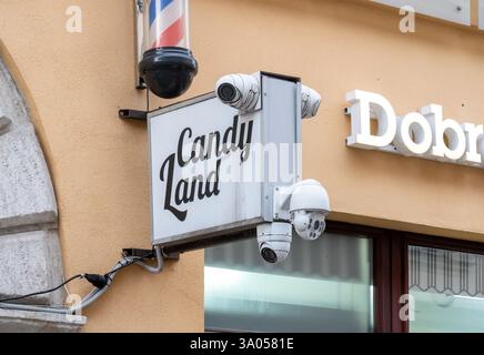 Überwachungskameras auf einem Candy Land Ladenschild, außen eines Süßwarenladens mit mehreren Überwachungskameras, die an ein Sicherheitssystem im Einzelhandelsgeschäft angeschlossen sind Stockfoto