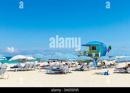 Liegestühle und Sonnenschirme und der 1st Street Lifeguard Tower am South Pointe Beach, South Beach, Miami Beach, Florida, USA Stockfoto