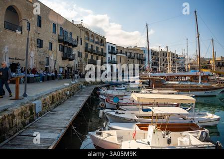 Girne, Nordzypern - 3. Februar 2025: Damm in der Innenstadt von Kyrenia mit Peple, Cafés, Geschäften, Fischerbooten und Wandertouristen, Nord Stockfoto