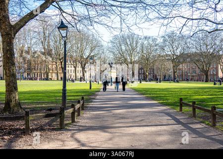 Menschen genießen die Frühlingssonne am Queen Square, Bristol, England Stockfoto