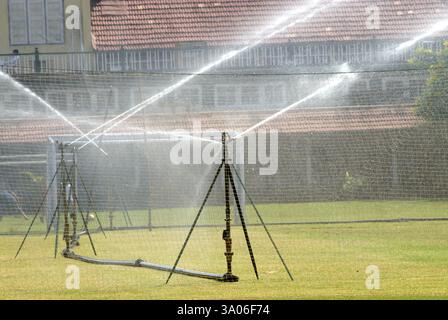 Sprinkleranlage, die Wasser für üppiges grünes Gras im Garten von Bombay Gymkhana in Azad Maidan, Bombay, sprengt Stockfoto