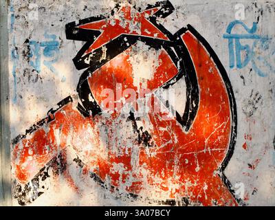 Verblasstes Hammer- und Sichelgemälde an einer verwitterten Wand in Kalkutta, das das Erbe des kommunistischen Einflusses in Westbengalen widerspiegelt. Stockfoto