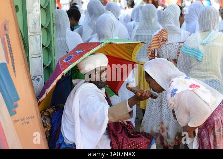 Ein äthiopisch-orthodoxer Priester segnet während der Sonntagsgebete die Gläubigen in einer örtlichen Kirche. Foto in Gondar, Äthiopien. Stockfoto