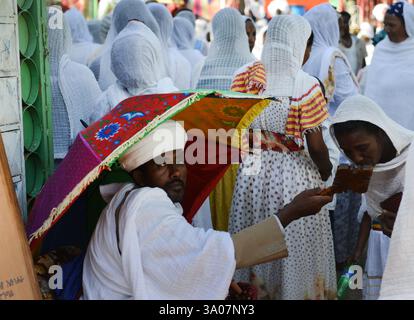 Ein äthiopisch-orthodoxer Priester segnet während der Sonntagsgebete die Gläubigen in einer örtlichen Kirche. Foto in Gondar, Äthiopien. Stockfoto