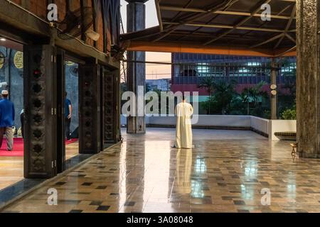 Bangkok, Thailand. März 2025. Ein Blick auf einen muslimischen Mann, der am ersten Tag des Ramadan bei Sonnenuntergang allein vor dem Gebetsraum betet, in der Stiftung des Islamischen Zentrums von Thailand, Bangkok der erste Tag des Ramadan ist ein bedeutender Anlass für Muslime auf der ganzen Welt. Es ist der Beginn eines Monats des Fastens, des Gebets, der Reflexion und der Gemeinschaft. (Foto: Nathalie Jamois/SOPA Images/SIPA USA) Credit: SIPA USA/Alamy Live News Stockfoto