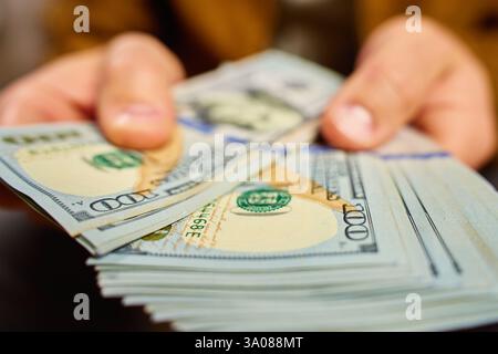 Mann zählt US-Dollar-Banknoten, Nahaufnahme. Cash Savings and Financial Wealth Konzept Stockfoto