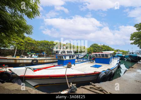 Fischerboot parkte am Hafen unter klarem blauem Himmel. Das Fischerboot liegt im kleinen Hafen Stockfoto
