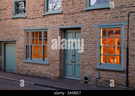 Das Ferienhaus hieß 'das alte Fischgeschäft' entlang der Marktstraße in der Abenddämmerung. Charlbury, Oxfordshire, England Stockfoto