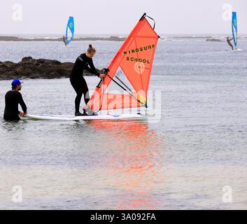 Eine junge Frau nimmt Windsurfunterricht in El Cotillo, Fuerteventura. Aufgenommen Im Dezember 2024. Winter Stockfoto