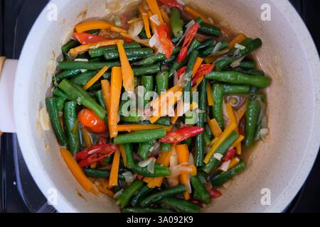 Indonesisches hausgemachtes Essen 'tumis kacang Panjang wortel' oder sautierte lange Bohnen und Karotten, Blick von oben. Stockfoto