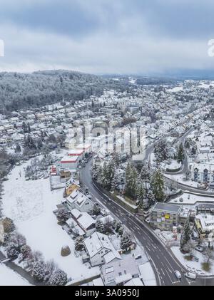 Winterdorf aus der Luft mit schneebedeckten Straßen und Gebäuden umgeben von Hügeln, Aidlingen, Boeblingen Bezirk, Deutschland, Europa Stockfoto