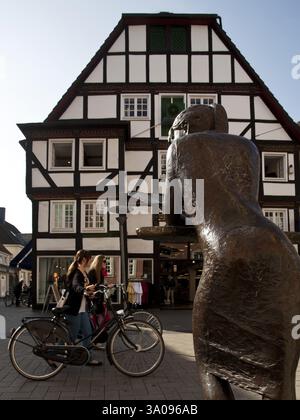 Bronzeskulptur vor einem Fachwerkhaus in der Fußgängerzone in der Altstadt von Lippstadt, Nordrhein-Westfalen, Deutschland, E Stockfoto