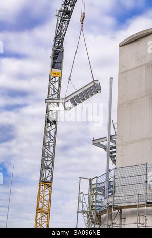 Kran hebt eine große Stahlkonstruktion auf einer Baustelle in die Luft, Treppenerweiterung zum neuen Turm des Calw-Bahnhofs an der neuen tr Stockfoto