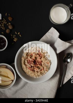 Frühstück auf dem Tisch mit Haferbrei, Obst und Milch Stockfoto