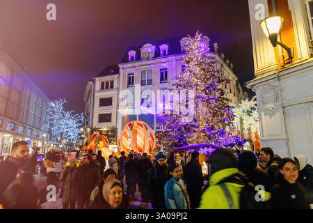 Mulhouse, Frankreich - 26. Dezember 2024: Lebhafte Weihnachtsmarktszene in Mulhouse mit einem großen, wunderschön dekorierten Baum und festlichen Lichtern, die den Weihnachtsmarkt erleuchten Stockfoto