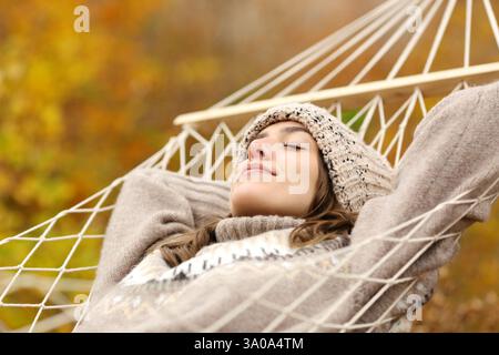 Entspannte Frau, die im Winter auf Hängematte liegend in der Natur schläft Stockfoto