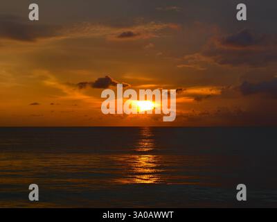 Goldener Sonnenuntergang über dem ruhigen Ozean vor der Dämmerung Stockfoto