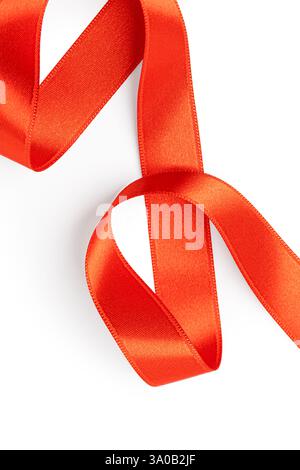 Rotes Satinband auf weißem Hintergrund, perfekt für Feiertage, Geschenke oder besondere Anlässe Stockfoto