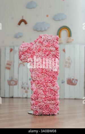 floral Nummer eins auf dem Hintergrund von Kinderaufklebern. Kinderzone zum ersten Geburtstag eines Mädchens Stockfoto