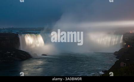 Die Niagarafälle werden bei Nacht beleuchtet und zeigen die majestätischen Hufeisenfälle und die amerikanischen Wasserfälle Stockfoto