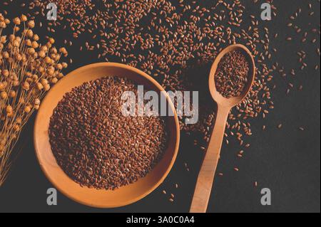 Bio-Müsli. Gesunde Ernährung. Flachssamen in einem Holzlöffel und Teller. Draufsicht Stockfoto