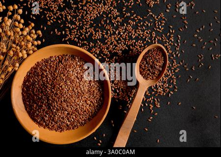 Bio-Müsli. Gesunde Ernährung. Flachssamen in einem Holzlöffel und Teller. Draufsicht Stockfoto