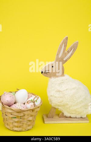 Nest mit Ostereiern und einem Kaninchen auf gelbem Hintergrund. Ostereier. Hochwertige Fotos Stockfoto