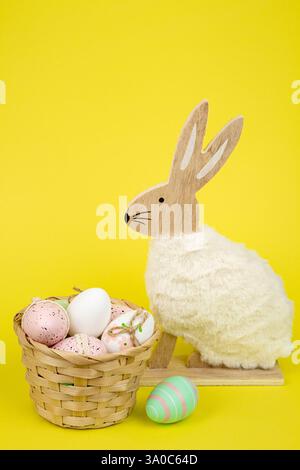 Nest mit Ostereiern und einem Kaninchen auf gelbem Hintergrund. Ostereier. Hochwertige Fotos Stockfoto