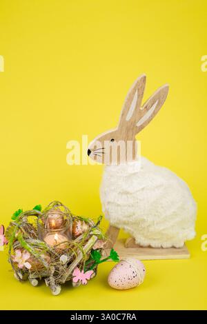 Nest mit Ostereiern und einem Kaninchen auf gelbem Hintergrund. Ostereier. Hochwertige Fotos Stockfoto