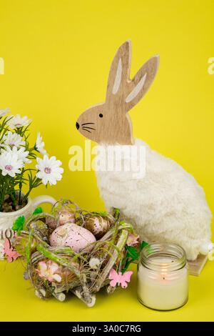 Nest mit Ostereiern und einem Kaninchen auf gelbem Hintergrund. Ostereier. Hochwertige Fotos Stockfoto