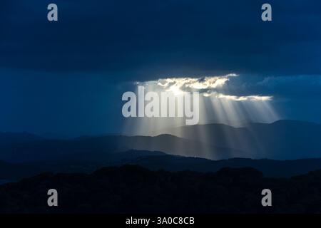 SONNENSTRAHLEN DURCH DUNKLE STURMWOLKEN ÜBER DEN KÜSTENBERGEN PALAFOLLS MARESME BARCELONA PROVINZ KATALONIEN SPANIEN Stockfoto