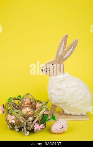 Nest mit Ostereiern und einem Kaninchen auf gelbem Hintergrund. Ostereier. Hochwertige Fotos Stockfoto