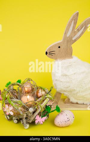 Nest mit Ostereiern und einem Kaninchen auf gelbem Hintergrund. Ostereier. Hochwertige Fotos Stockfoto