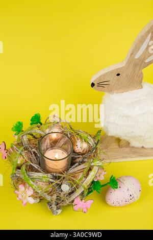 Nest mit Ostereiern und einem Kaninchen auf gelbem Hintergrund. Ostereier. Hochwertige Fotos Stockfoto