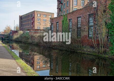 Historische Backsteinmühle spiegeln sich an klaren Tagen in einem ruhigen Kanal wider. Stockfoto