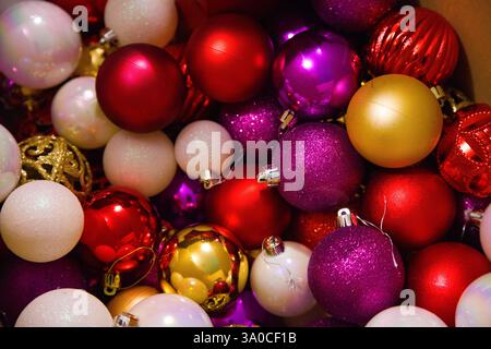 Nahaufnahme farbenfroher Weihnachtsbaumschmuck in Rot-, Gold- und Rosa-Tönen zur Dekoration eines Weihnachtsbaums. Stockfoto