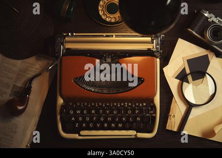 Schreibmaschine, Lupe und Papiere auf dem Schreibtisch des Detektivs Stockfoto