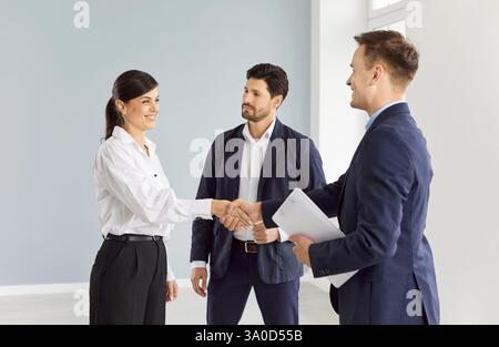 Glückliche Frau im Büro, die Hand schüttelt mit einem Mann, Nahaufnahme Stockfoto