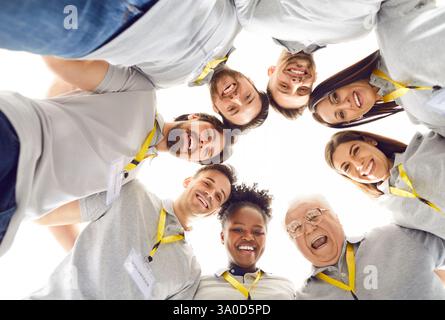Ein Team aus fröhlichen, vielfältigen Freiwilligen und Freunden, die sich zusammendrängen und Spaß haben Stockfoto