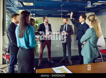 Gruppe von Geschäftsleuten, die im Konferenzraum stehen und Kaffee trinken Stockfoto