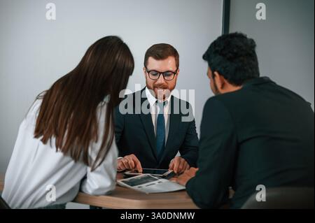 Zwei Männer und Frauen sitzen im Büro und arbeiten. Stockfoto